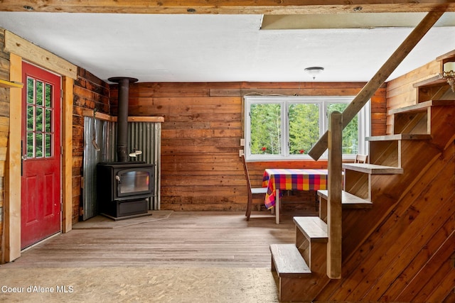 sitting room featuring plenty of natural light, wood finished floors, and a wood stove