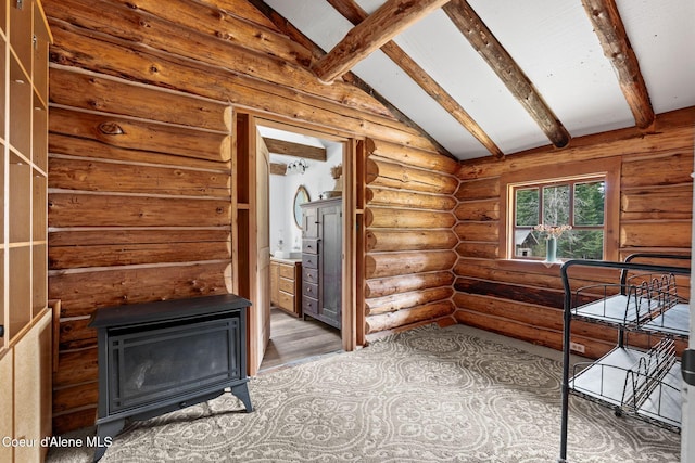 interior space with ensuite bathroom, lofted ceiling with beams, rustic walls, and wood finished floors