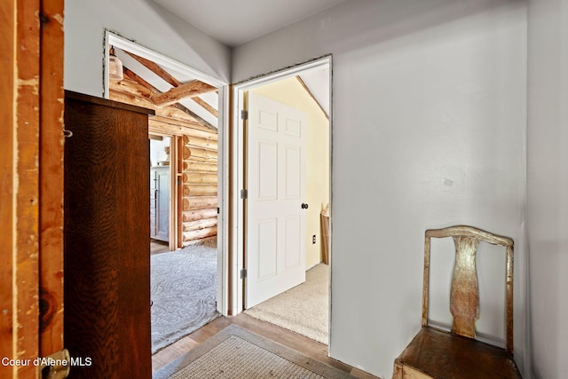 corridor featuring log walls and wood finished floors