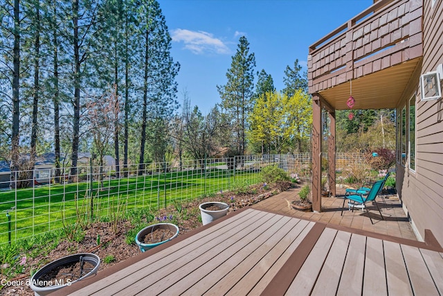 wooden deck featuring a lawn and fence