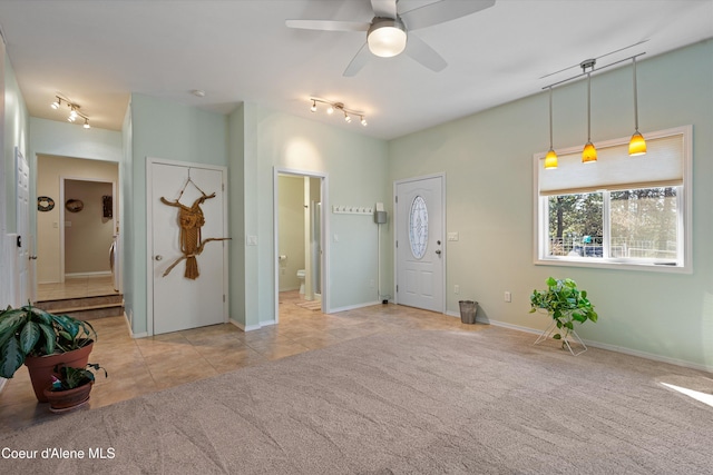 carpeted entrance foyer with tile patterned floors, baseboards, ceiling fan, and rail lighting