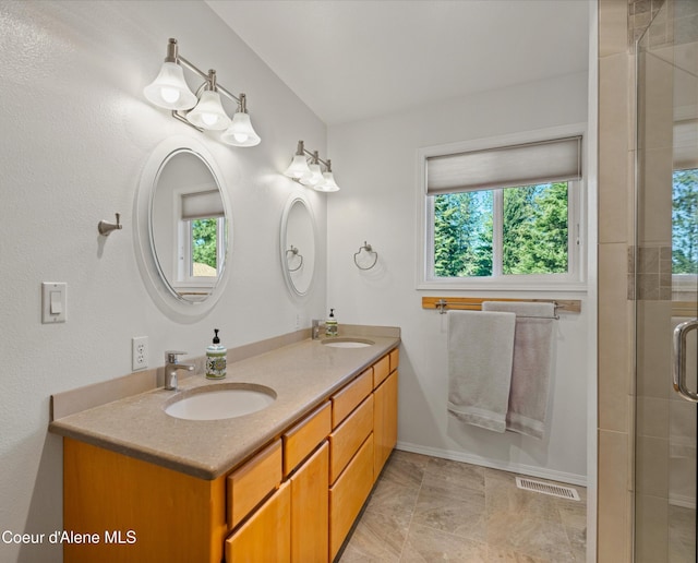 full bath featuring double vanity, a sink, a shower stall, and visible vents