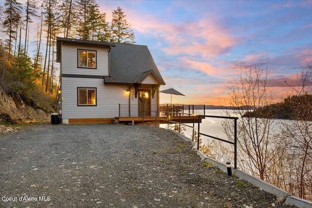 view of front of property featuring roof with shingles and a deck