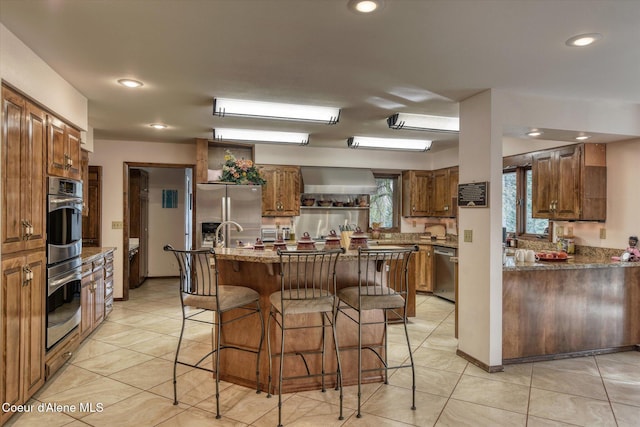 2885 S Folsom Ridge Rd, Coeur Dalene, ID 83814 - kitchen featuring appliances with stainless steel finishes, wall chimney range hood, a breakfast bar area, healthy amount of natural light, and recessed lighting