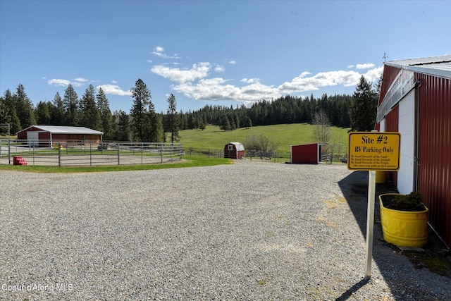 2885 S Folsom Ridge Rd, Coeur Dalene, ID 83814 - view of dirt / gravel road with an outbuilding, a view of rural / pastoral area, and a forest view