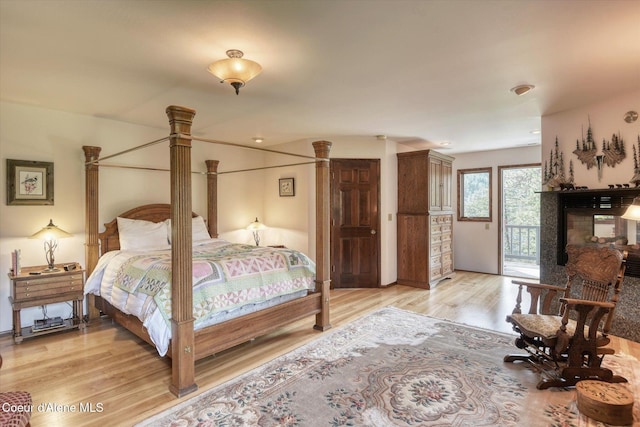 2885 S Folsom Ridge Rd, Coeur Dalene, ID 83814 - bedroom featuring access to exterior, light wood-style flooring, and a multi sided fireplace