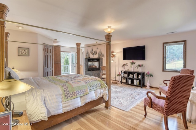 2885 S Folsom Ridge Rd, Coeur Dalene, ID 83814 - bedroom with light wood-type flooring, a multi sided fireplace, and ornate columns