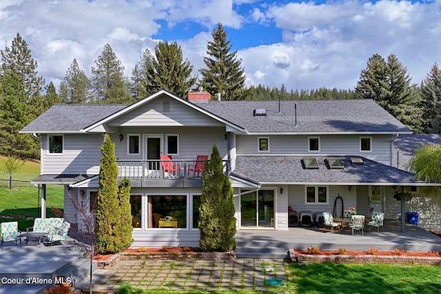 2885 S Folsom Ridge Rd, Coeur Dalene, ID 83814 - back of house featuring a patio area, a chimney, a balcony, and a shingled roof