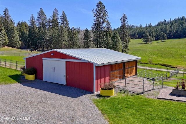 2885 S Folsom Ridge Rd, Coeur Dalene, ID 83814 - view of outdoor structure featuring a rural view, gravel driveway, an exterior structure, and a forest view