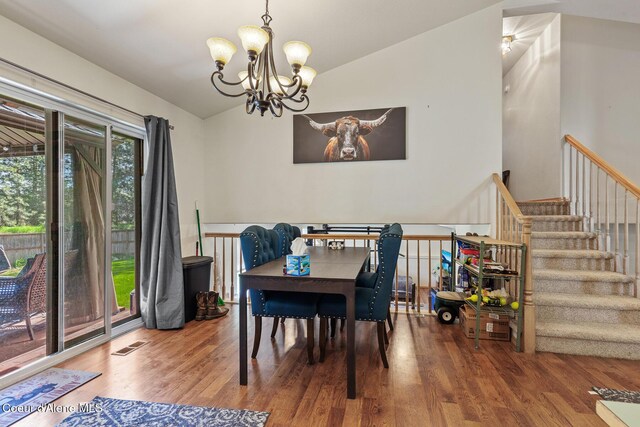 dining area featuring an inviting chandelier, wood finished floors, vaulted ceiling, and visible vents