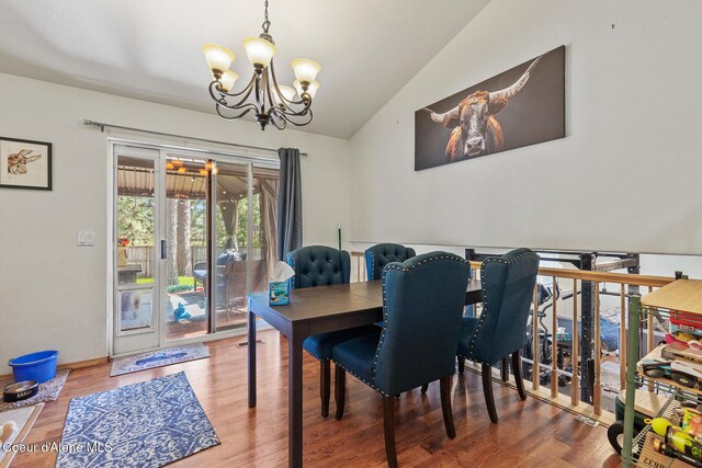 dining room with lofted ceiling, wood finished floors, and a chandelier