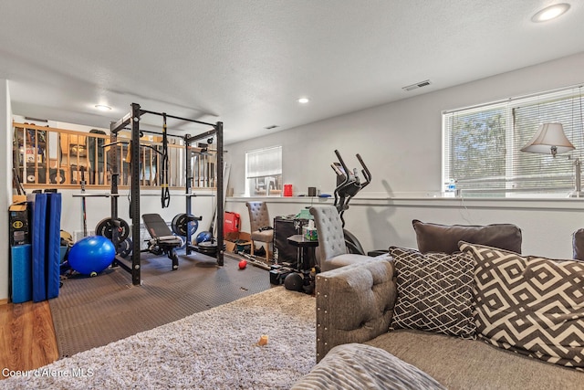workout area with recessed lighting, wood finished floors, and visible vents