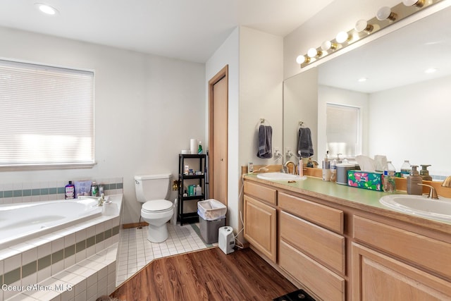 full bath with double vanity, a sink, a bath, and toilet