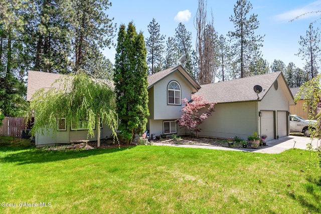 view of front facade featuring an attached garage, a front lawn, fence, and driveway