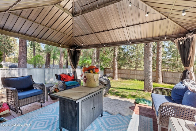 view of patio with a deck, a gazebo, an outdoor living space, and a fenced backyard