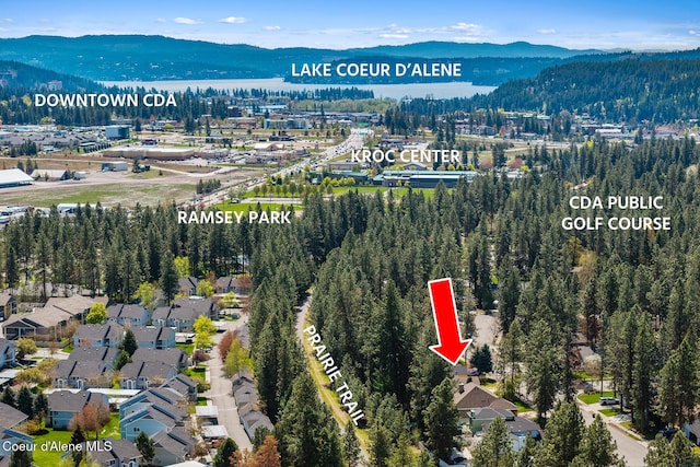 drone / aerial view featuring a water and mountain view and a forest view