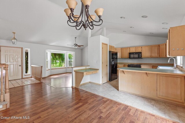 3868 N Palmer Dr, Coeur Dalene, ID 83815 - kitchen with black appliances, vaulted ceiling, open floor plan, a peninsula, and light countertops