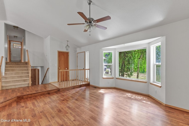 3868 N Palmer Dr, Coeur Dalene, ID 83815 - unfurnished room featuring vaulted ceiling, wood finished floors, stairway, and ceiling fan