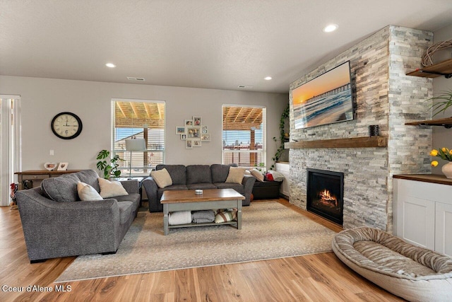 living area with recessed lighting, light wood-style floors, and a fireplace