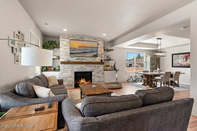 living area with a fireplace, visible vents, recessed lighting, and light wood-style flooring