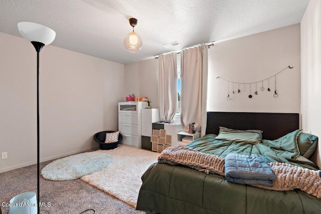 carpeted bedroom featuring a textured ceiling, visible vents, and baseboards