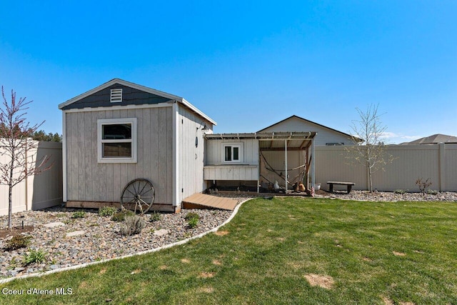 exterior space featuring a lawn, an outdoor structure, a shed, and a fenced backyard