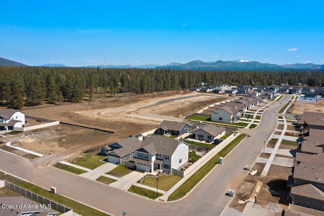 aerial view featuring a mountain view, a view of trees, and a residential view