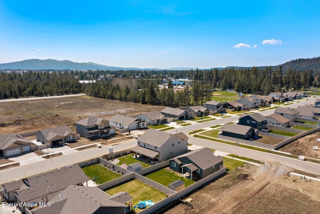 aerial view featuring a wooded view, a mountain view, and a residential view