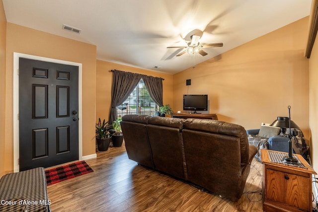living area with wood finished floors, a ceiling fan, visible vents, baseboards, and lofted ceiling