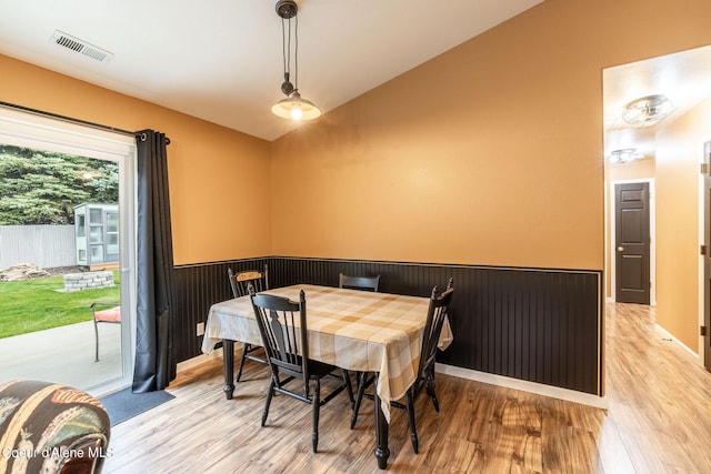 dining room with visible vents, light wood-style floors, and lofted ceiling