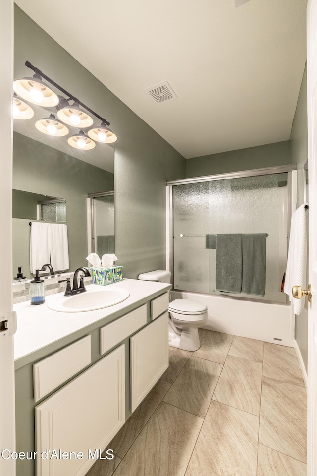 bathroom with bath / shower combo with glass door, toilet, visible vents, and vanity