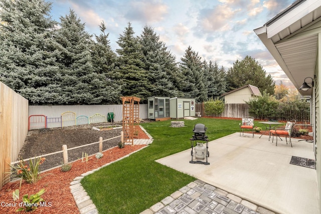 view of yard featuring an outdoor structure, a storage unit, a patio area, and a fenced backyard