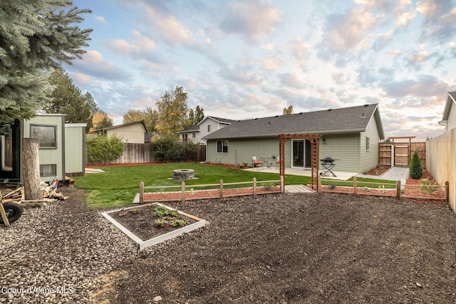 view of yard with a pergola, a patio, an outdoor fire pit, a fenced backyard, and a vegetable garden