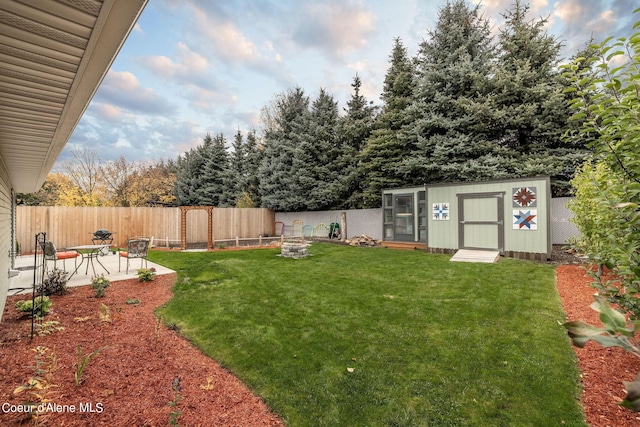 view of yard with an outbuilding, a patio, and a fenced backyard