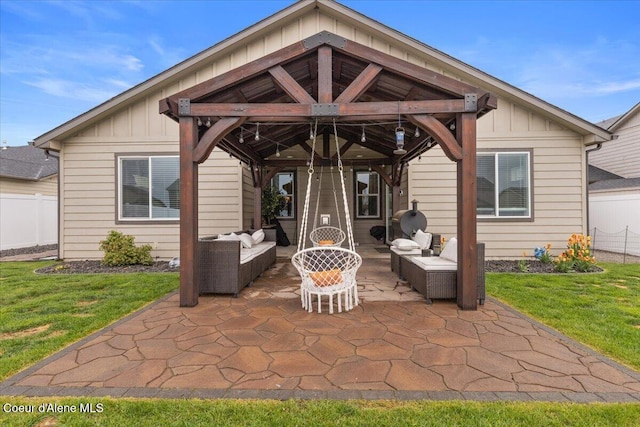 rear view of property with a gazebo, outdoor lounge area, board and batten siding, and a yard