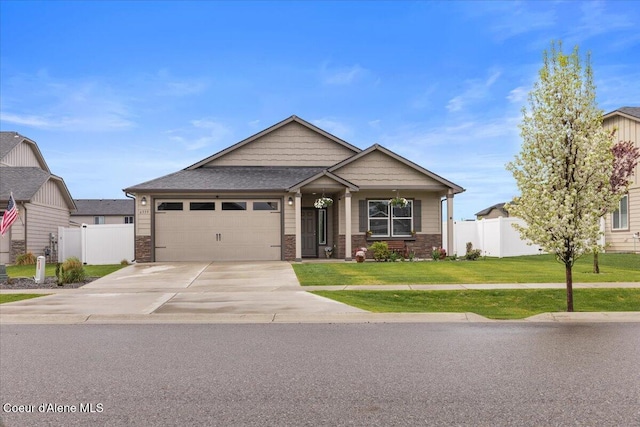 craftsman-style house with fence, an attached garage, driveway, and a front lawn