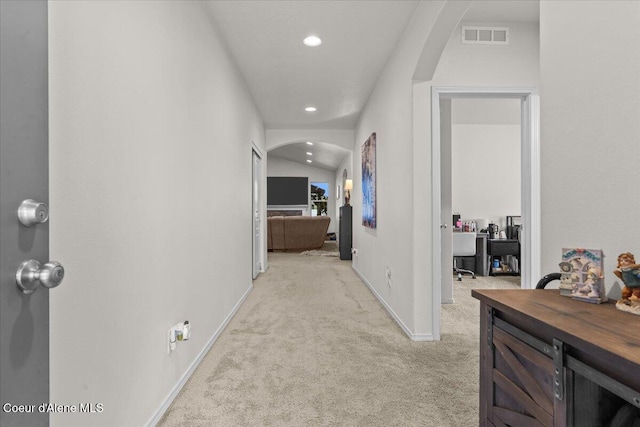 hall with visible vents, baseboards, recessed lighting, light colored carpet, and arched walkways
