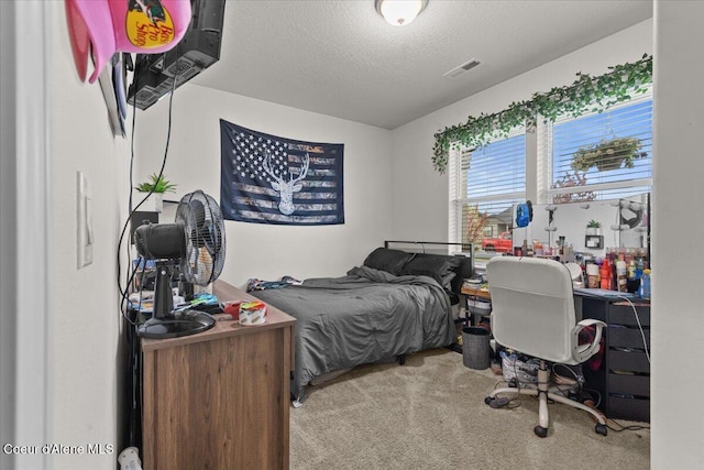 carpeted bedroom with a textured ceiling and visible vents