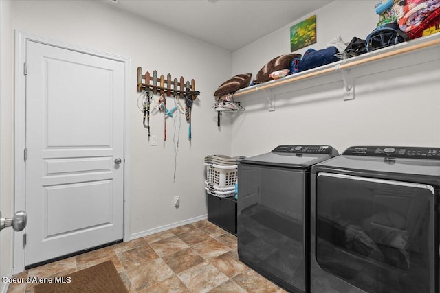 laundry room with separate washer and dryer, baseboards, laundry area, and stone finish flooring