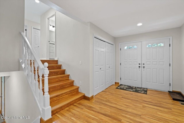 entryway featuring light wood-style floors, baseboards, stairway, and recessed lighting