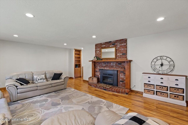 living area featuring recessed lighting, a textured ceiling, and wood finished floors