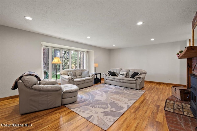 living room featuring baseboards, a textured ceiling, and wood finished floors
