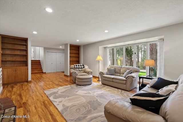 living area featuring recessed lighting, stairs, a textured ceiling, and wood finished floors