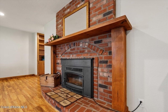 room details with baseboards, wood finished floors, and a fireplace