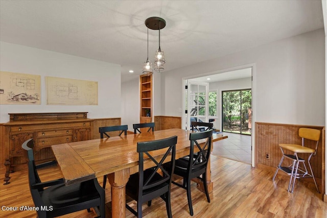 dining room featuring light wood-style floors and a wainscoted wall