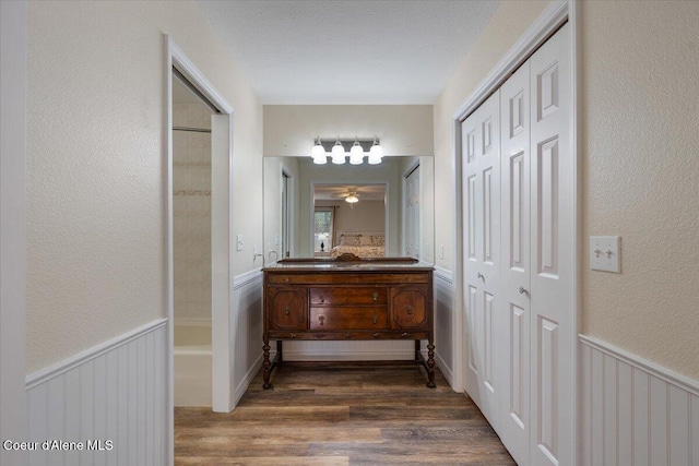 hallway featuring wainscoting and wood finished floors