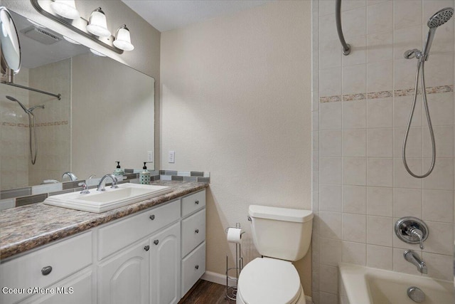 full bath featuring vanity, toilet, wood finished floors, shower / bathing tub combination, and visible vents