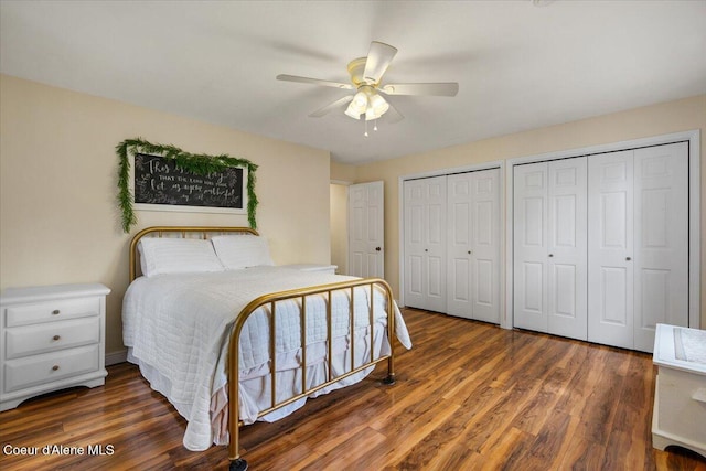 bedroom with two closets, ceiling fan, and wood finished floors