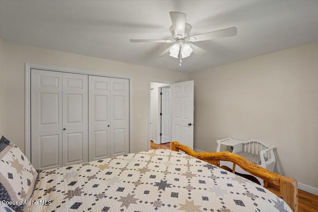 bedroom featuring baseboards, a ceiling fan, a closet, and wood finished floors
