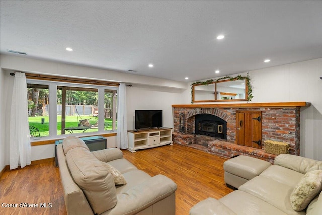 living area featuring recessed lighting, wood finished floors, and visible vents